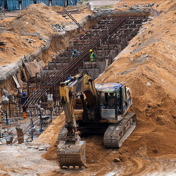 Baustelle mit Fundamentarbeiten und Bagger im Einsatz